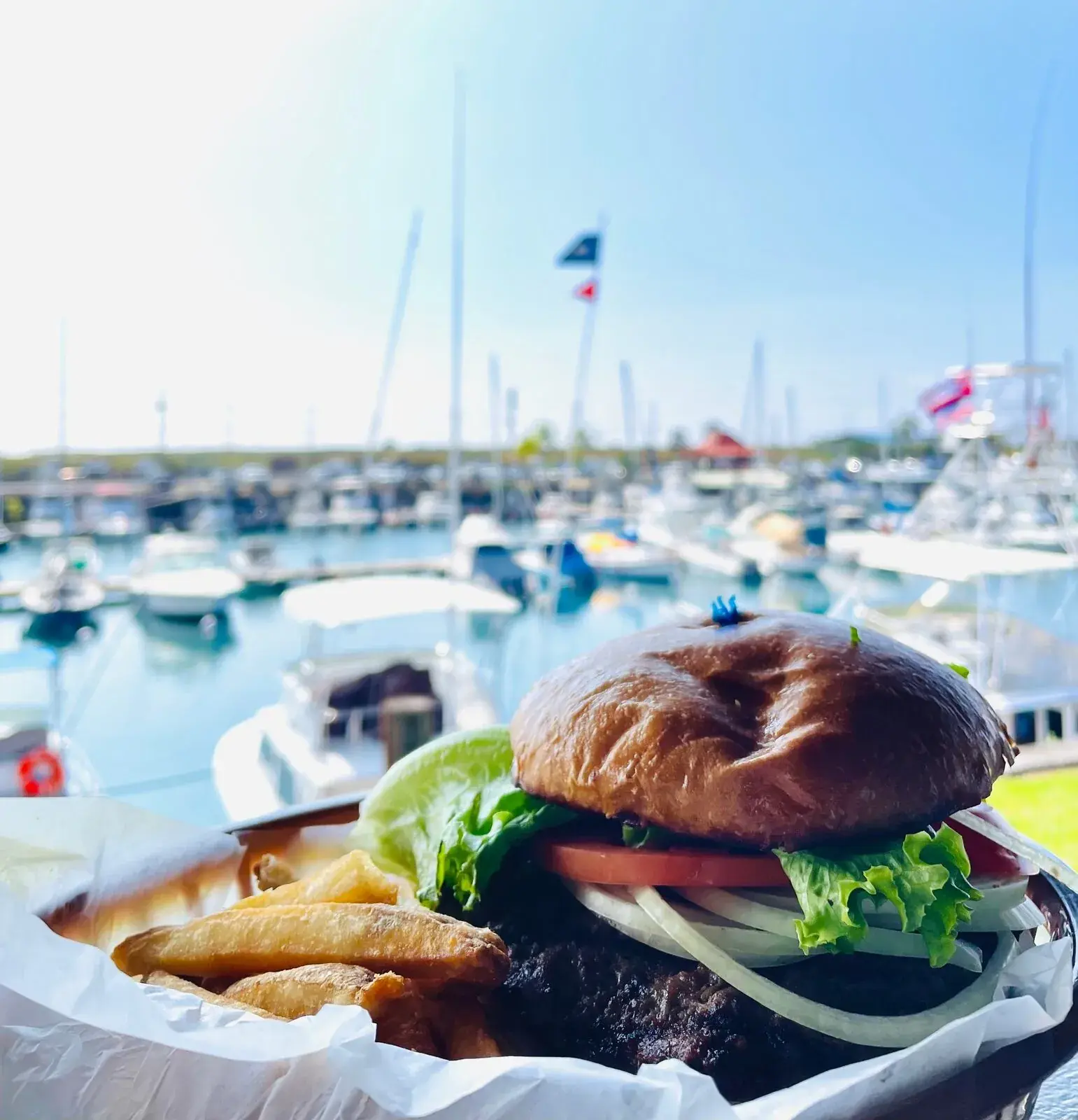 Cheeseburger and fries with a marina view at Harbor House Kona