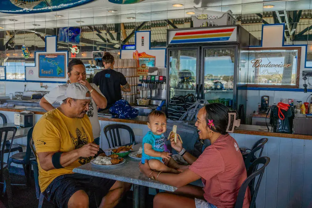 Family enjoying lunch in the open-air dining room at Harbor House Kona
