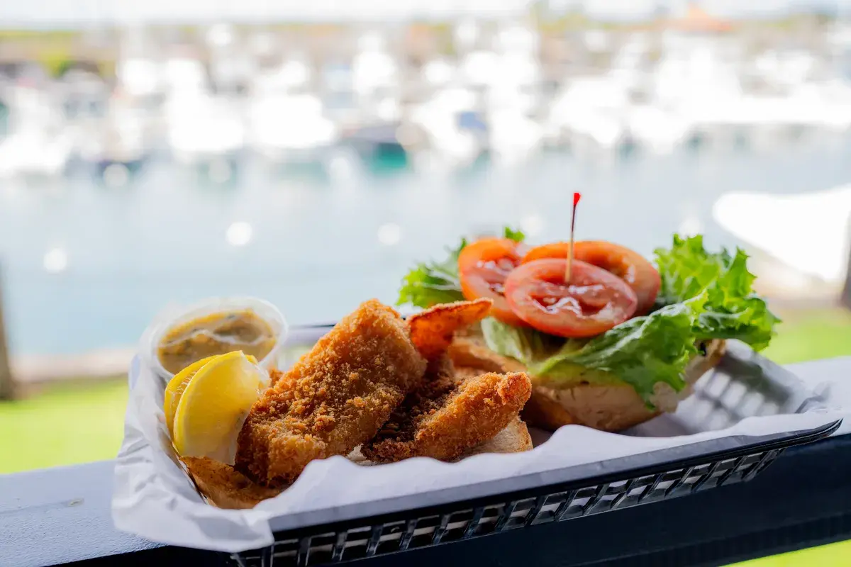 Crispy fish sandwich basket with a marina view at Harbor House Kona