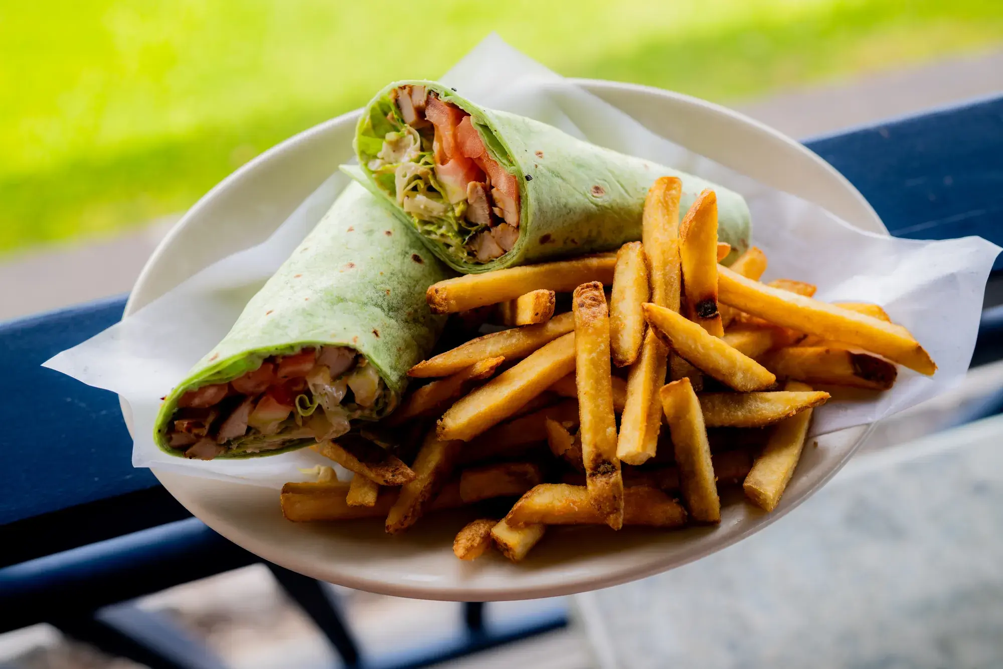 Chicken Caesar Wrap at Harbor House Kona, Spinach tortilla, romaine lettuce, parmesan cheese, tomatoes, & Caesar dressing.