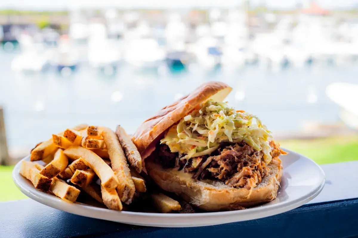 Pulled pork sandwich topped with slaw at Harbor House Kona