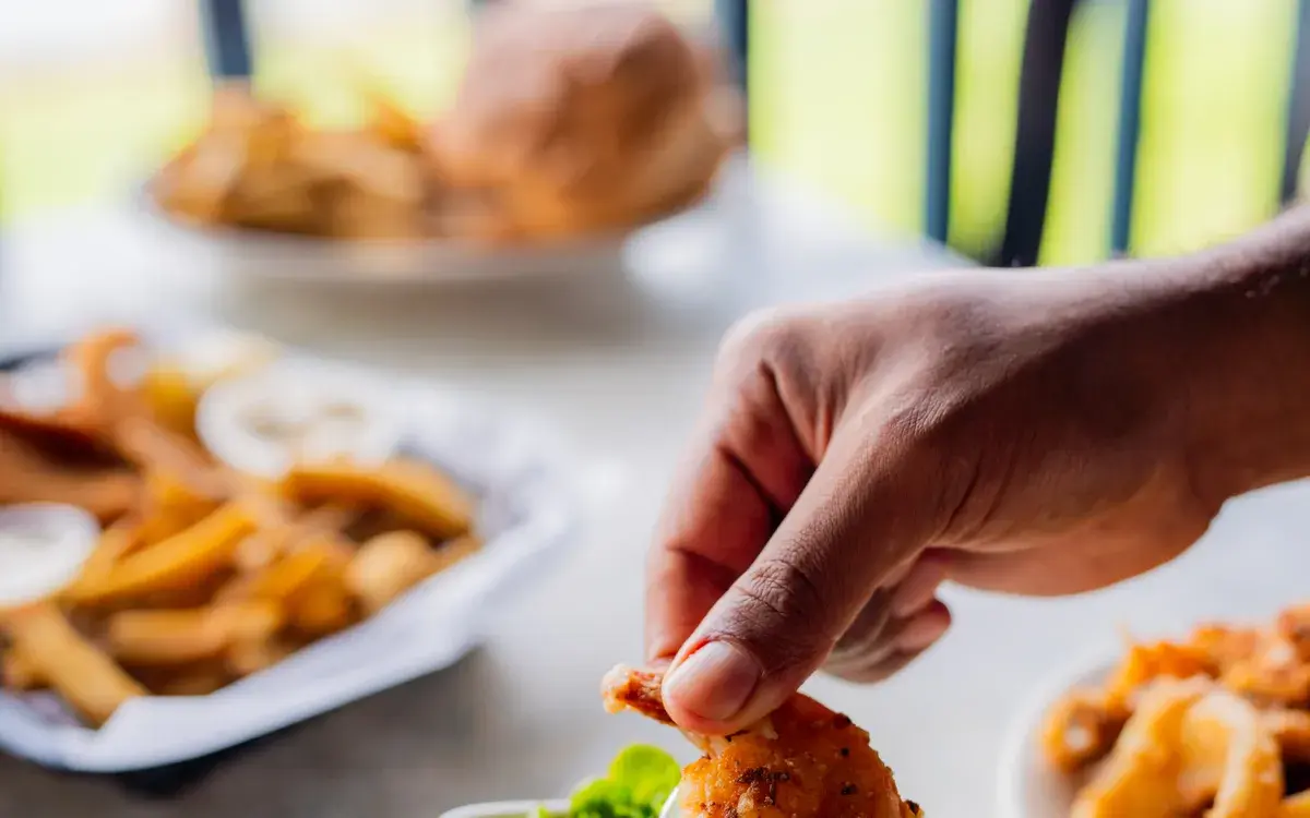 Hands sharing pupus and onion rings at Harbor House Kona