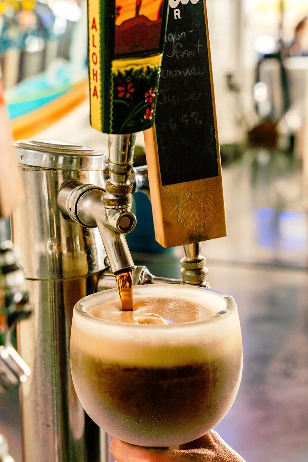 Dark draft beer pouring into a frosty schooner at Harbor House Kona