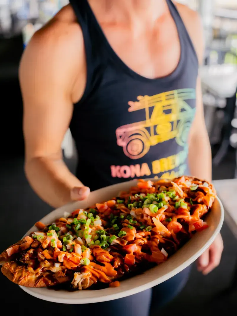 Harbor House team member serving fresh poke nachos in the dining room
