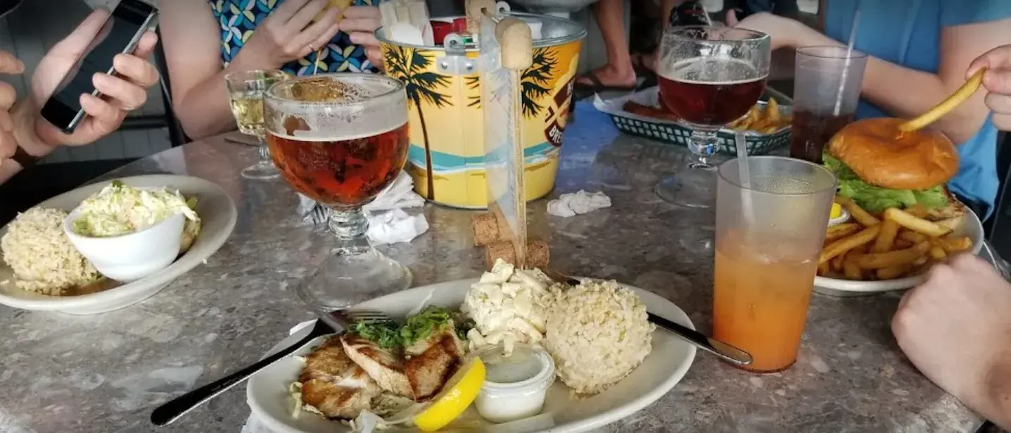 A spread of Harbor House Kona dishes and drinks with a Honokohau Harbor view