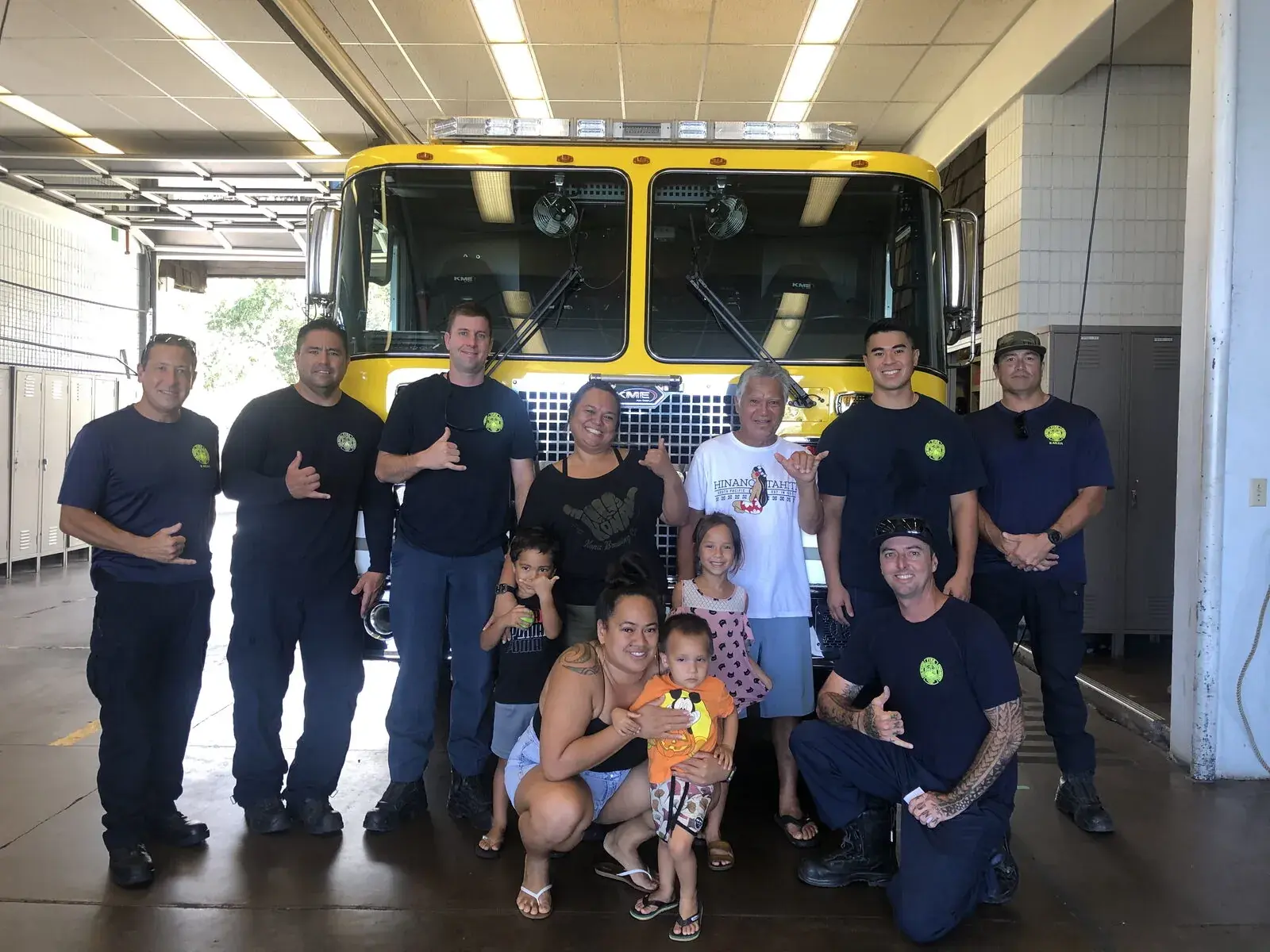 Hawaii County firefighters and family in front of a fire truck, supported by Harbor House and the Daniel R. Sayre Memorial Foundation
