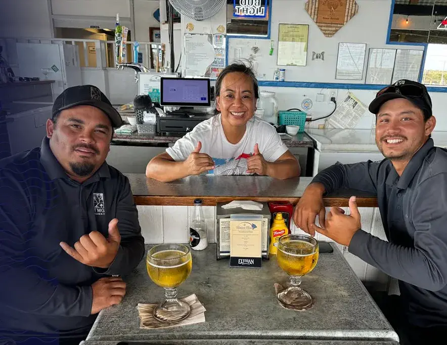 Harbor House team members throwing shakas behind the counter
