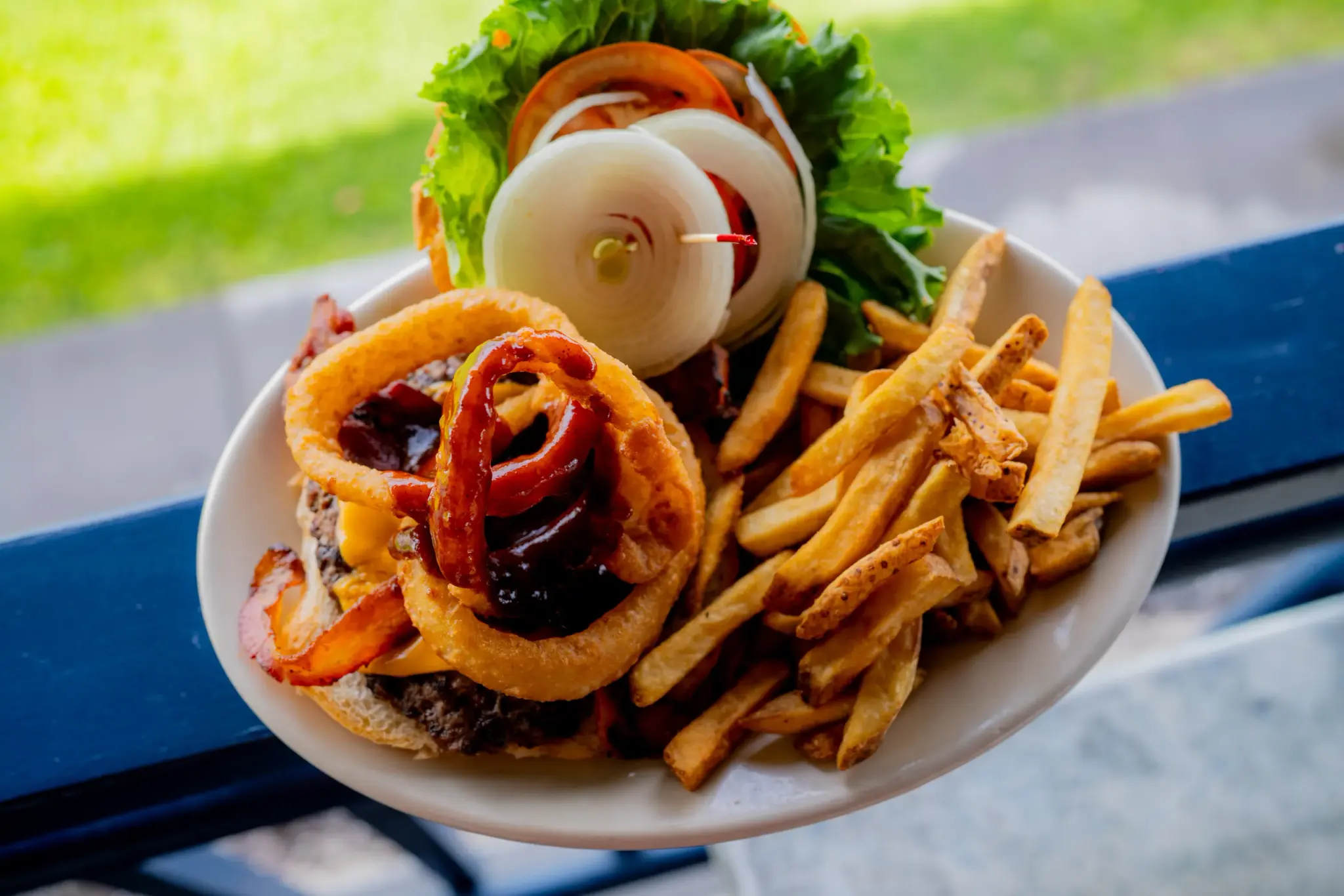 Paniolo Burger at Harbor House Kona, Loaded with onion rings, crispy bacon and BBQ sauce.